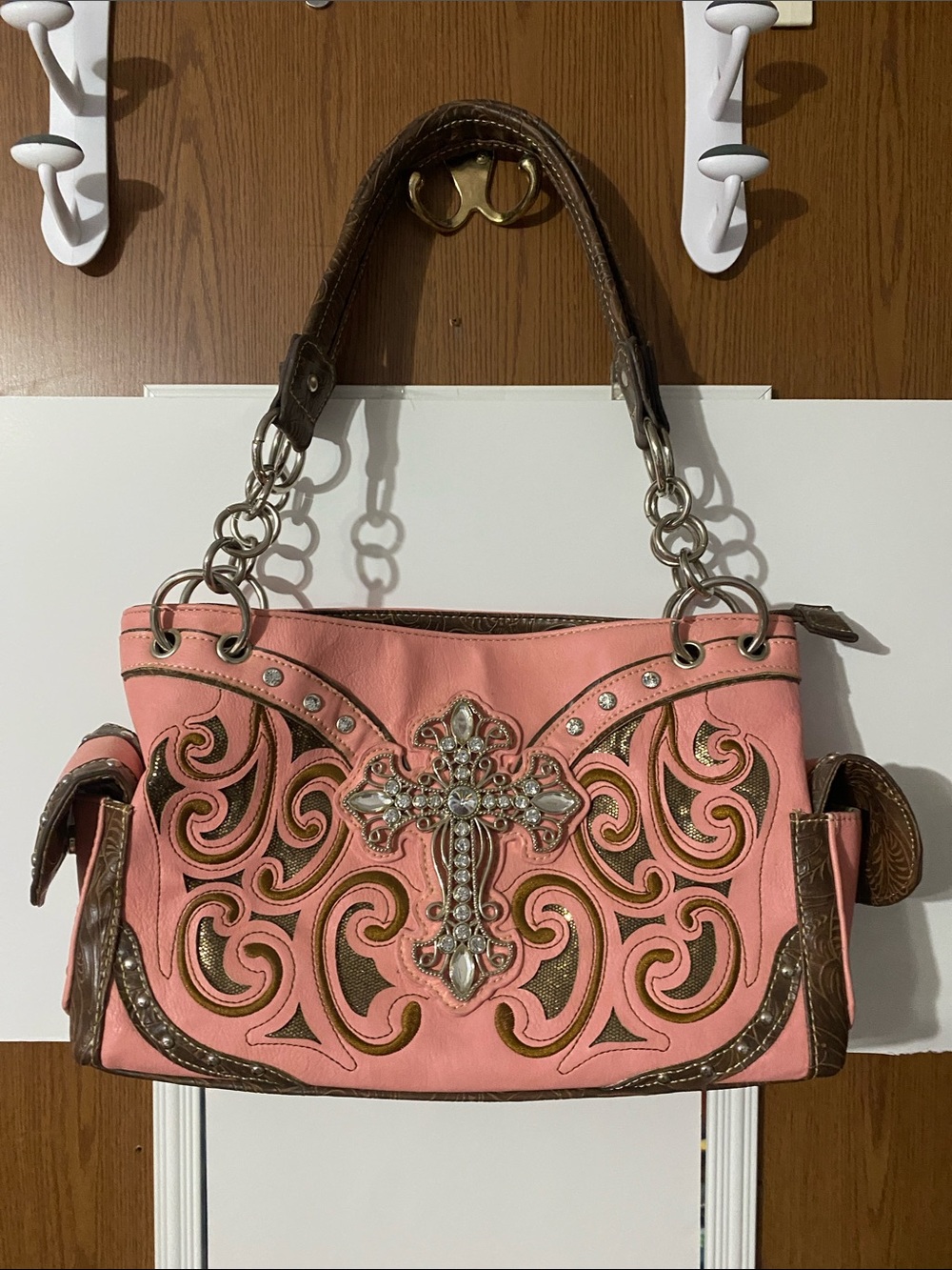 Pink/brown leather purse with a detailed cross.